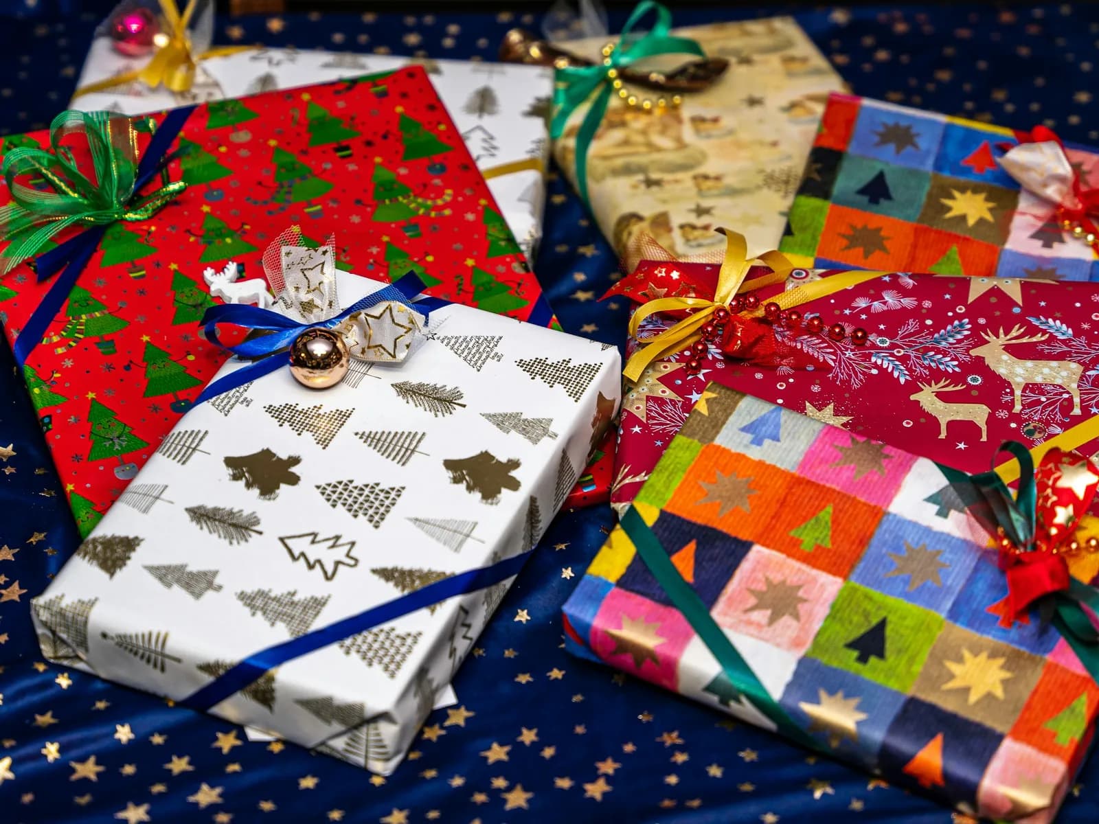Colorfully wrapped Christmas presents spread on a starry tablecloth
